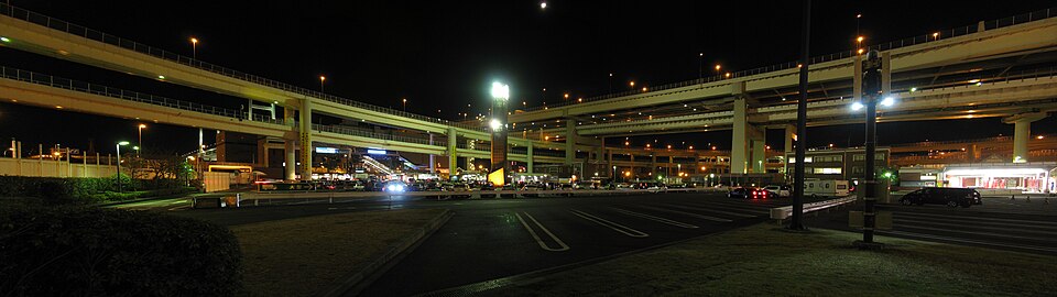 Daikoku Parking Area at night, a wide car park under the curving decks of the expressway junction